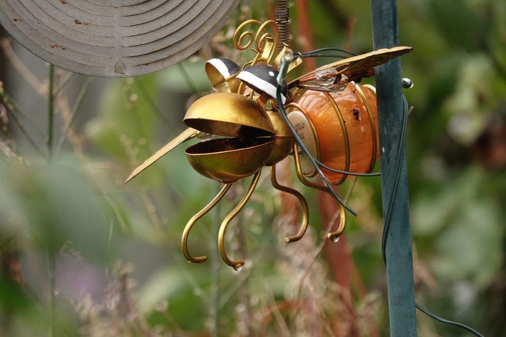 Metallic bee garden ornament in garden