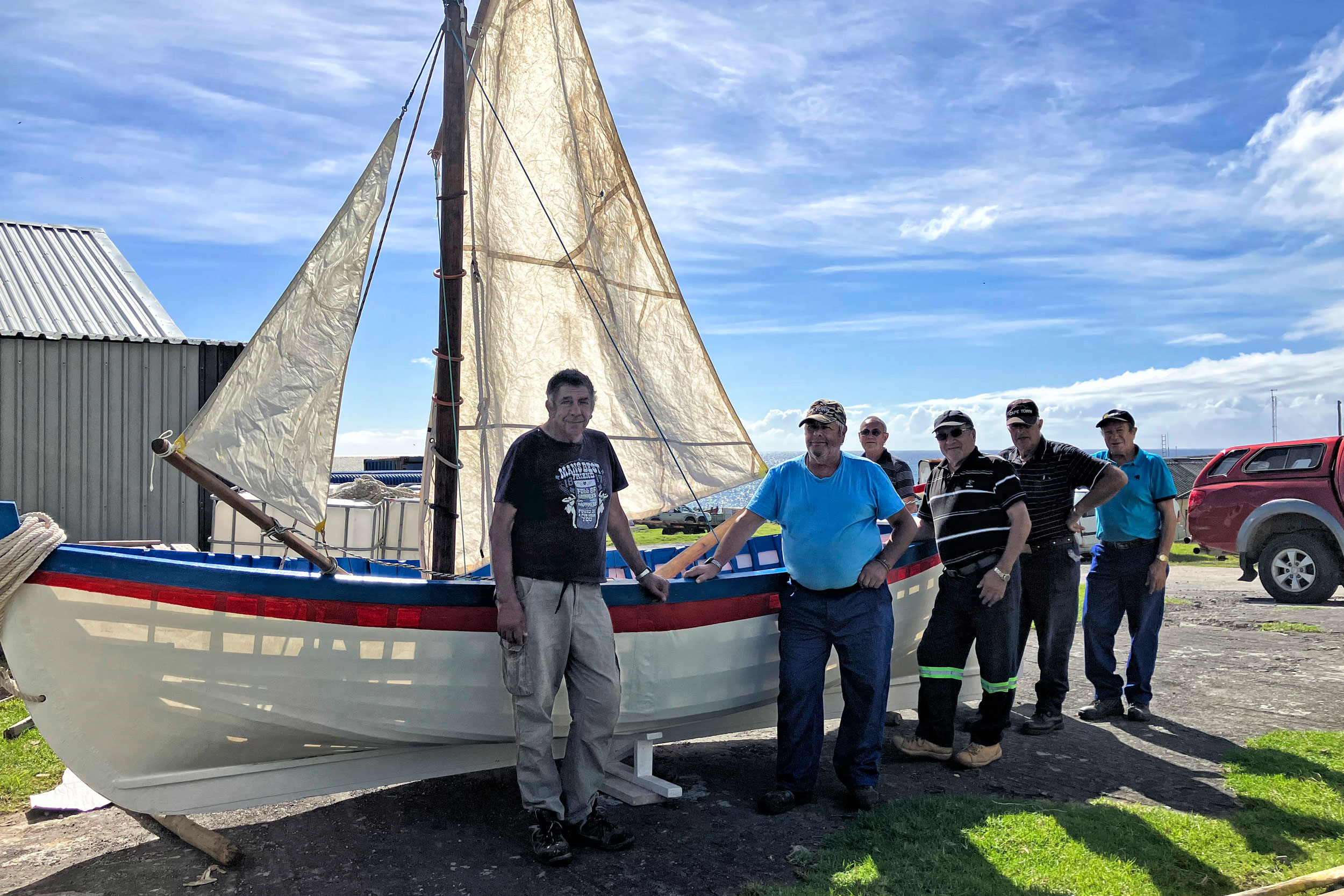 Tristan da Cunha elders standing before longboat they built