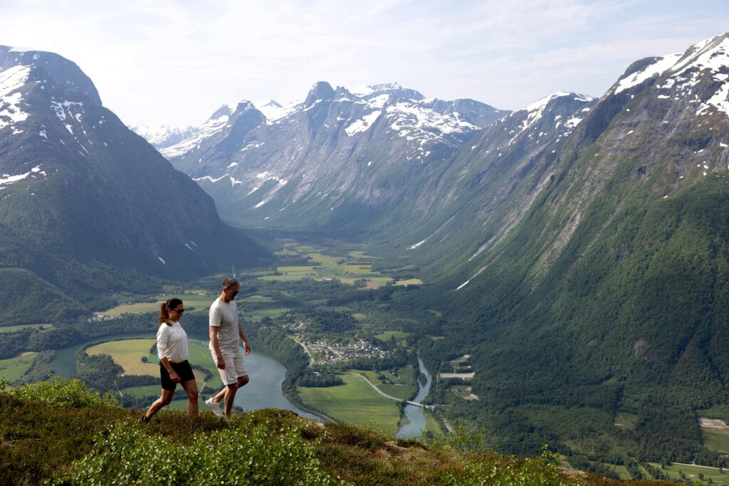 Two people walking in mountain scenery.