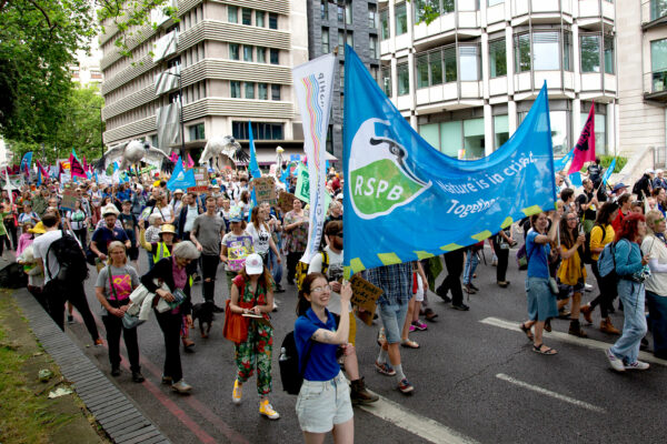 People hold up an RSPB banner as part of a march through London