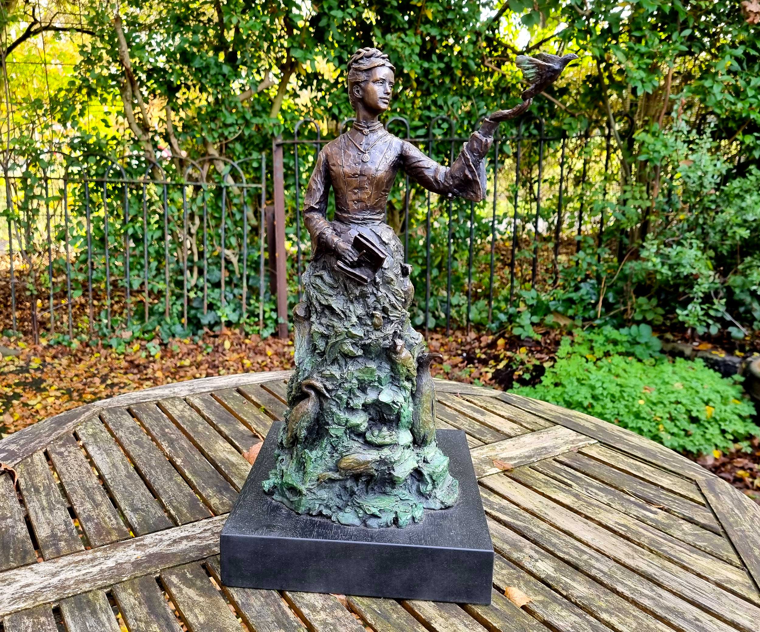 A maquette (small replica) of a planned statue showing a woman surrounded by birds, with one bird landing on her outstretched hand.