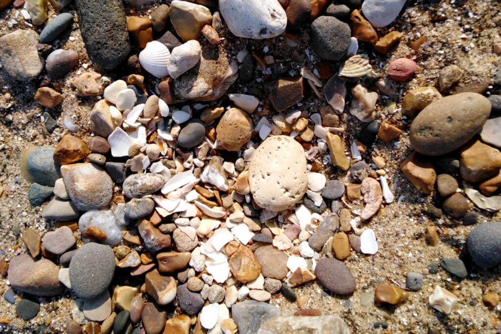 A large white pebble among other pebbles on a beach.