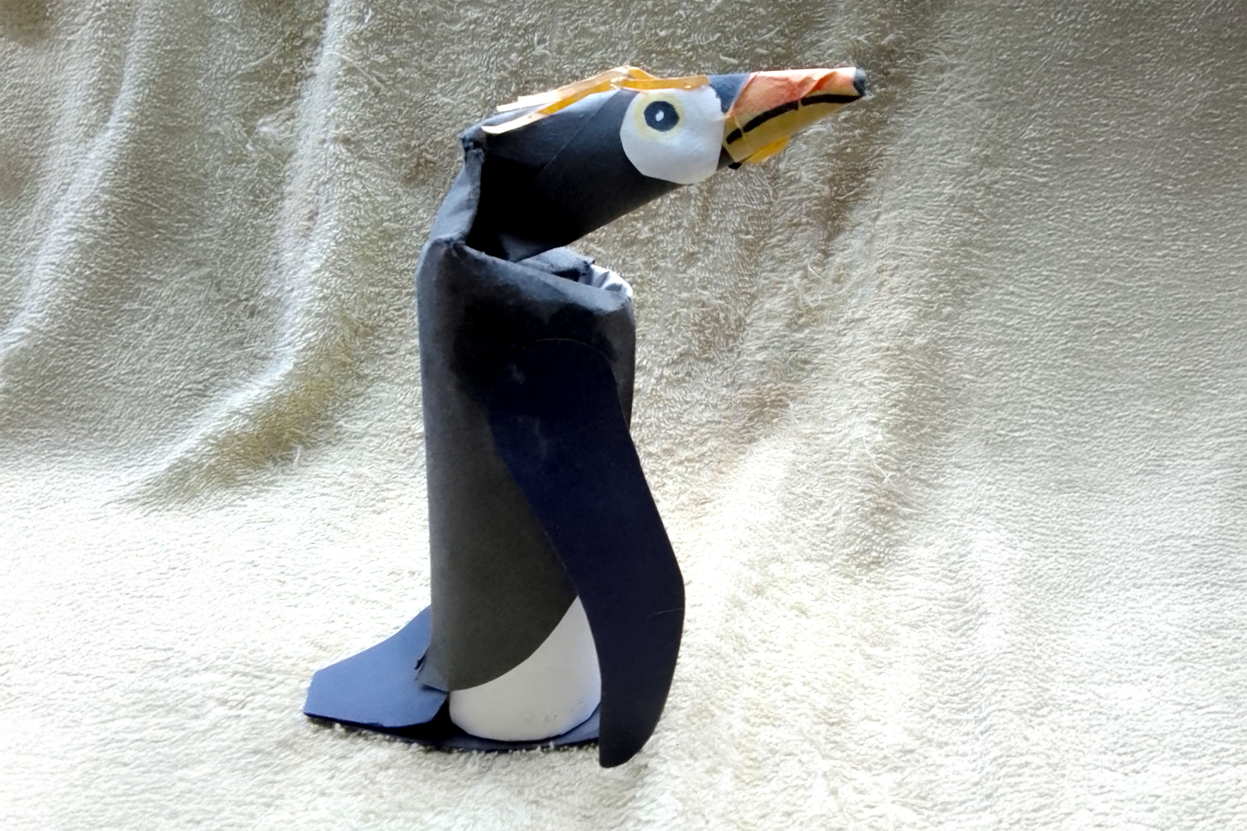 A model penguin made from paper and a cardboard tube