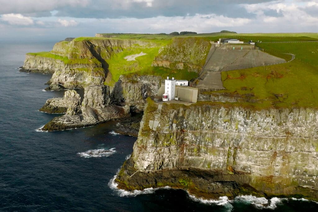 A white building on cliffs above the sea