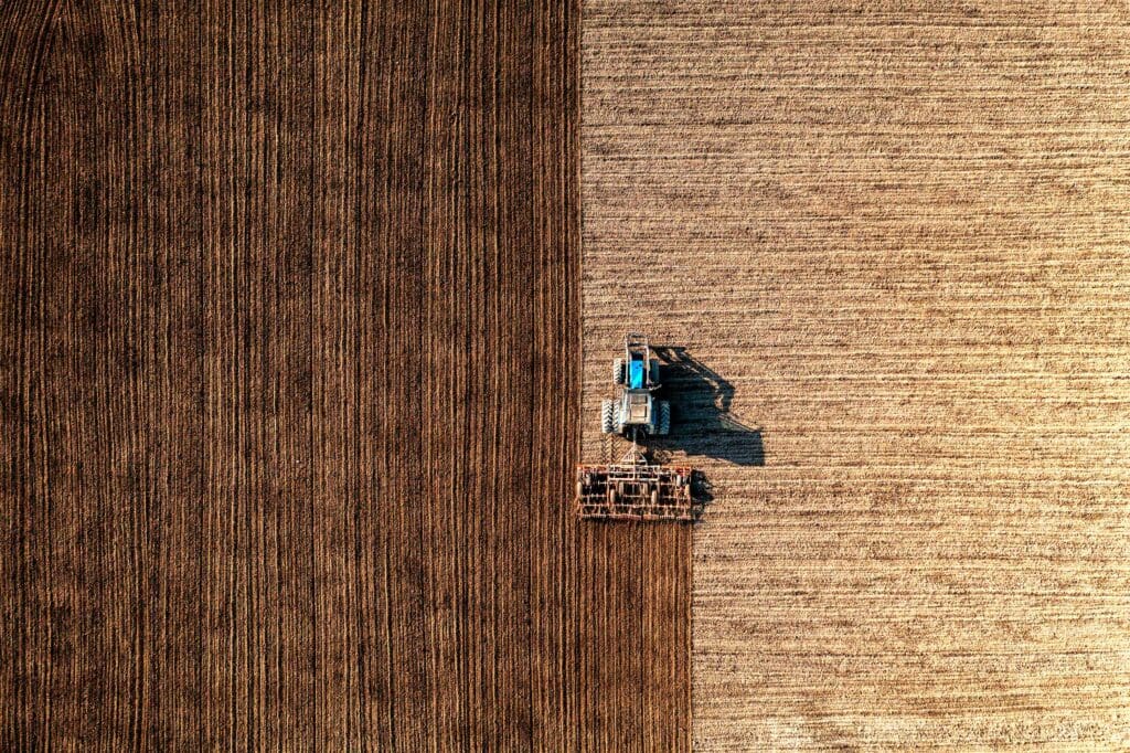 Top view of a tractor harrowing soil on an agriculture field