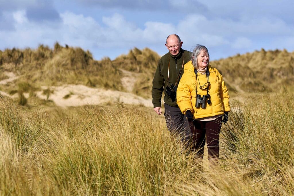 Jacinta and Dave walk through dunes