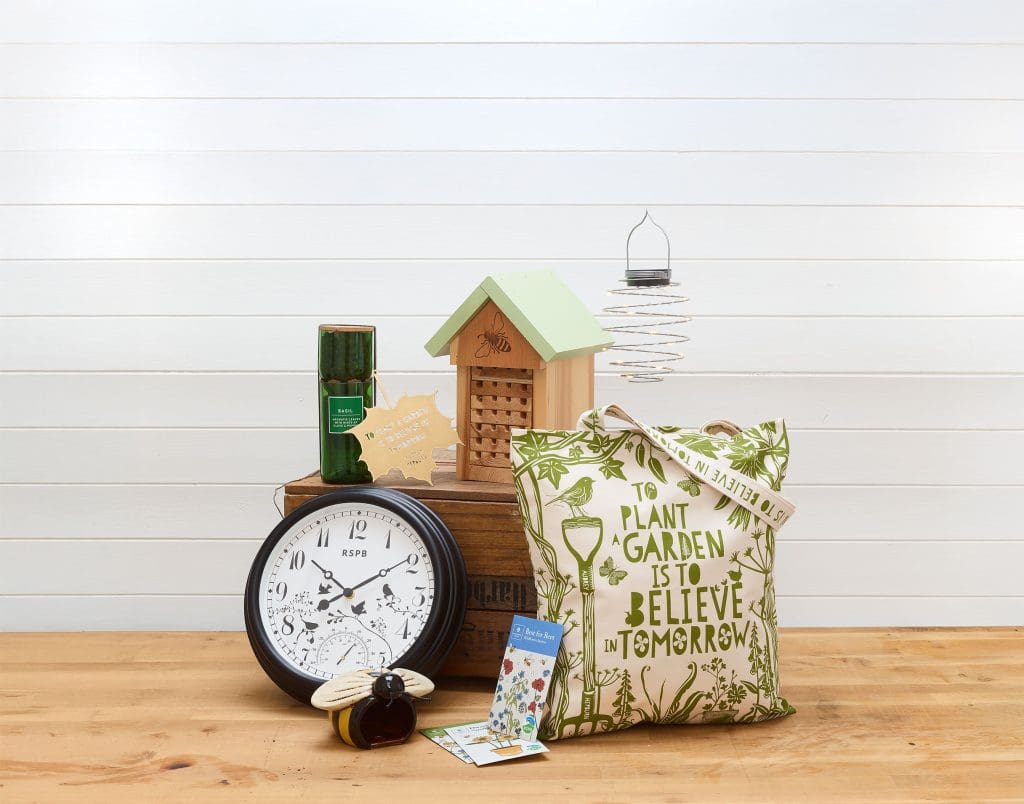 A selection of spring-themed RSPB shop products, including a clock, bag and bug hotel.