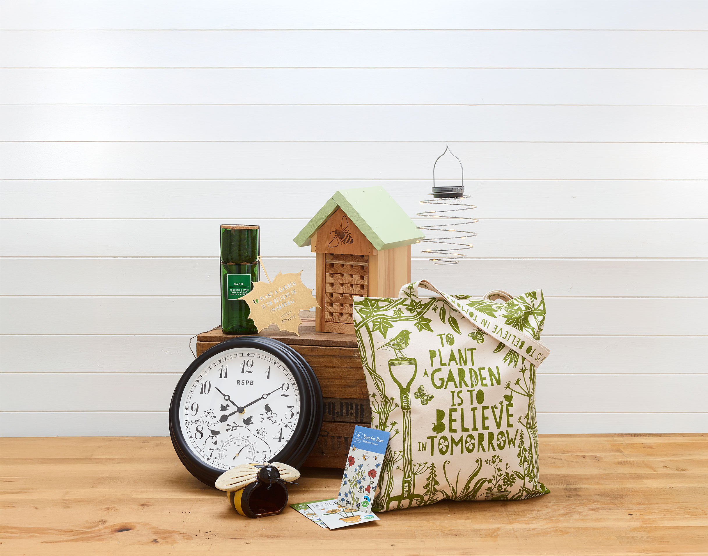 A selection of spring-themed RSPB shop products, including a clock, bag and bug hotel.
