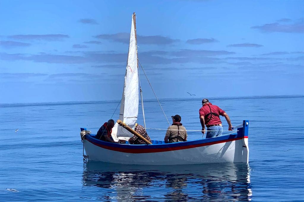 A dinghy boat on still water with four passengers on board