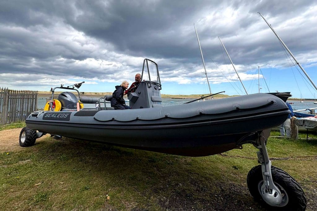 A man and woman stood on an amphibious boat on the land