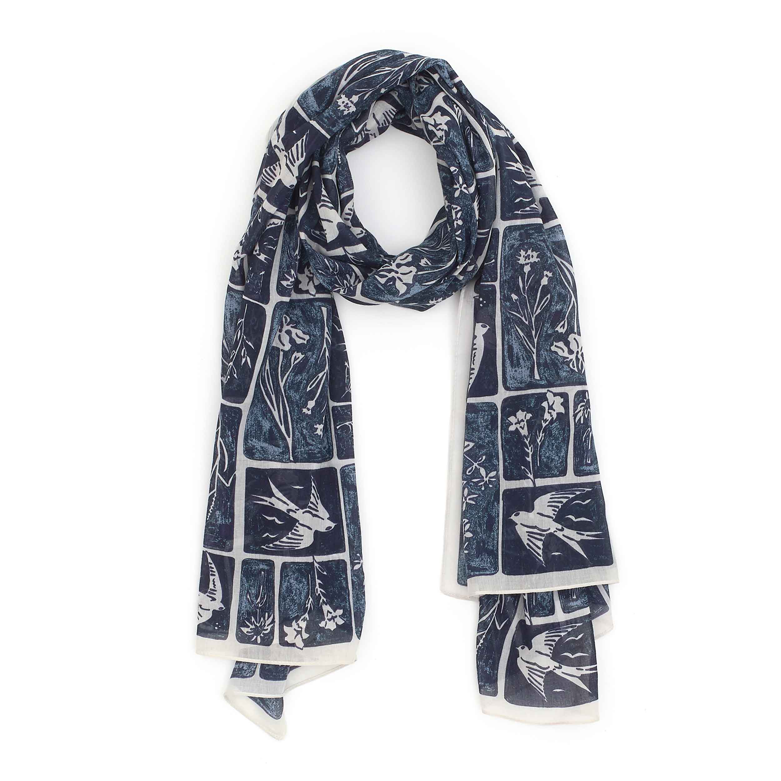Dark blue and pale cream scarf, with lino-print-style scenes of swifts and meadow flowers in different-sized squares and rectangles arranged in a linear design