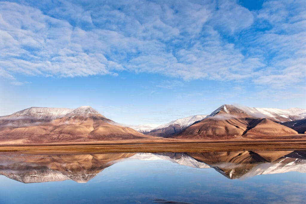 Mountains reflected in water on a sunny day.