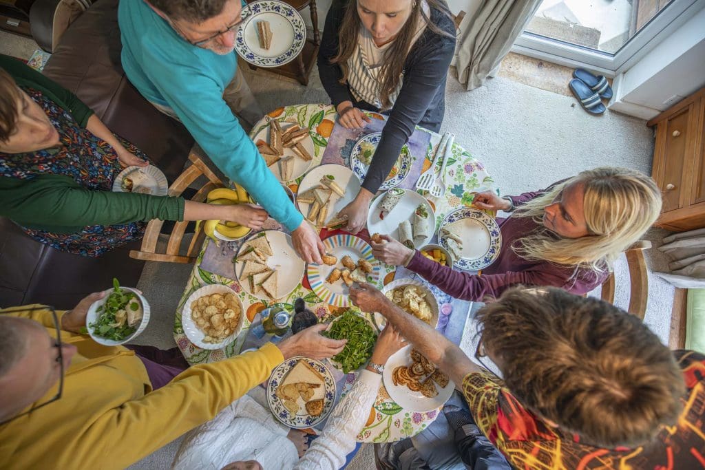 A photo looking down on a group of people sharing food around a table
