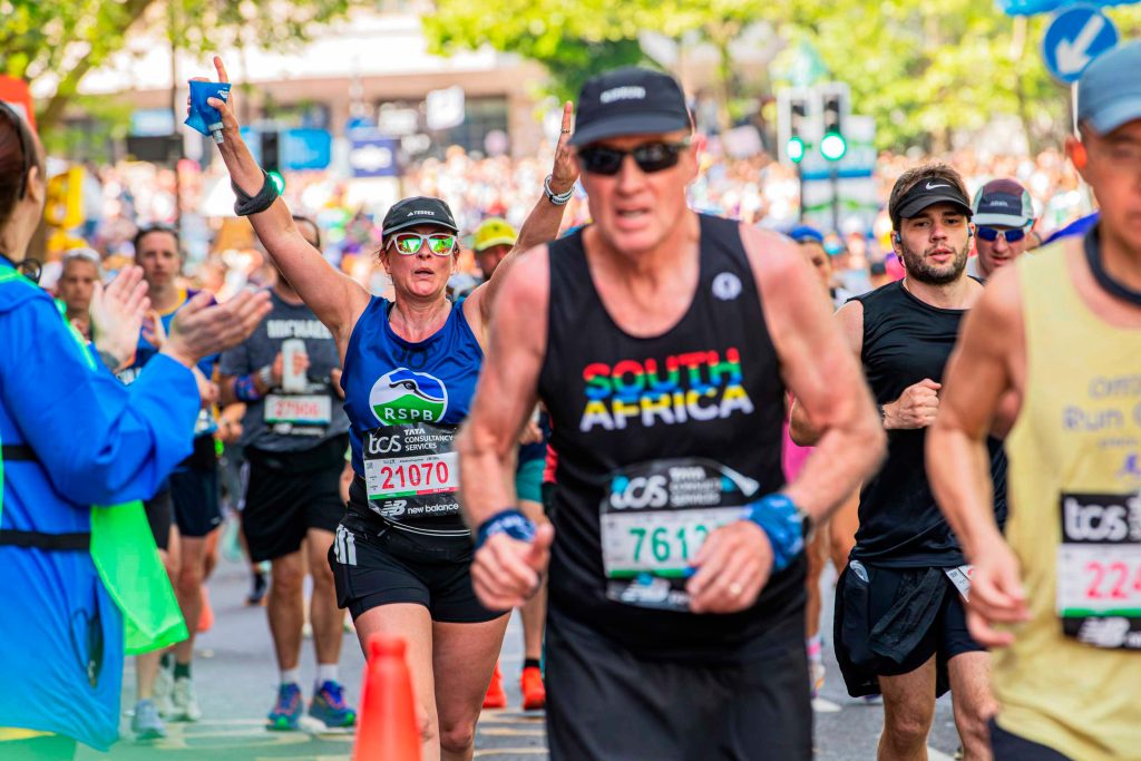 IMAGE._05A7480.Jo-Saxby--running-the-London-Marathon.Credit-BenAndrew Jo Saxby has her arms aloft as crowds clap