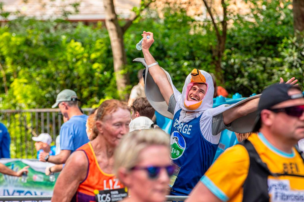 IMAGE_05A7678.George-Cook-running-the-London-Marathon.CreditBenAndrew George Cook has his arms oustretched to show his gull wings. His head peeps through a gull beak head covering