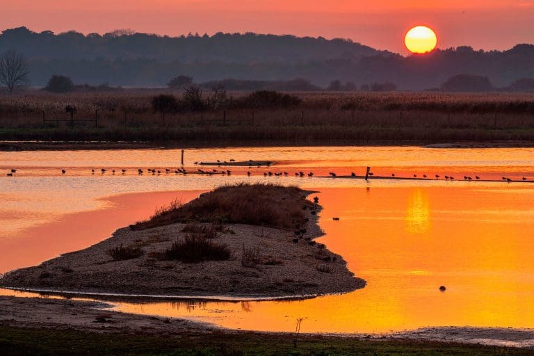 The sun sets over water at RSPB Minsmere