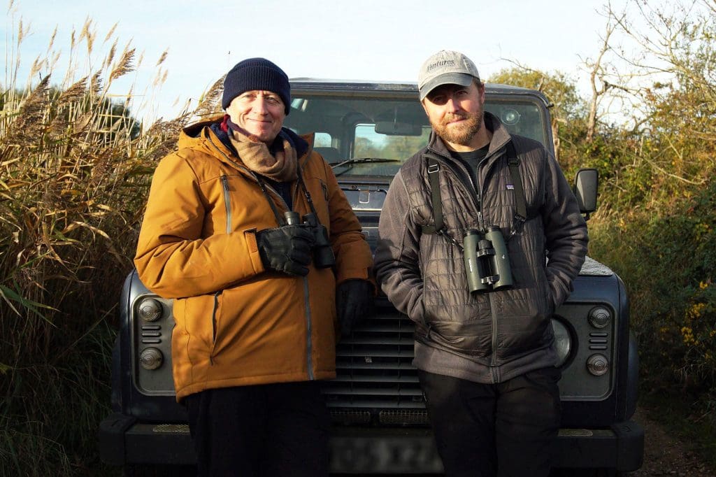 Credit-Dom-Davies,-Frank-Films-(3) Adrian Edmondson and Samuel West lean against the bonnet of a Land Rover, parked in a narrow lane