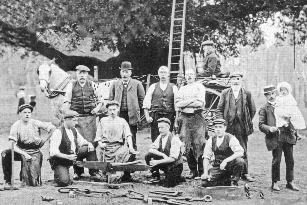 ELH-2065---Sherwood-Forest---Fixing-Chains-to-Major-Oak-c1905-North-East-Midland-Photographic-Record A black and white photo of several men standing or kneeling in front of Major Oak, with a ladder behind them and tools on the ground in front