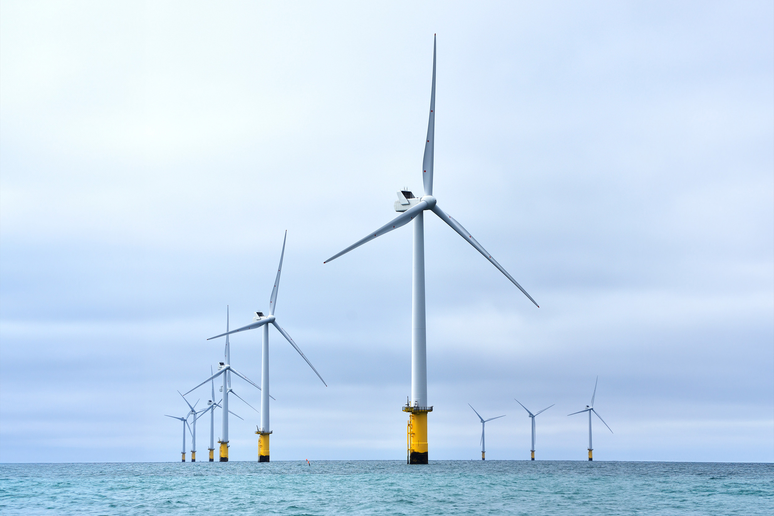 An offshore wind farm, with several wind turbines in a line